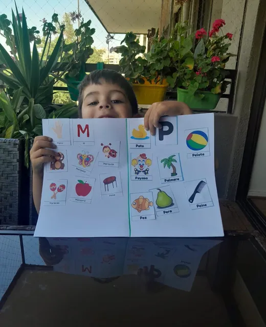Niño mostrando una lámina de actividades
