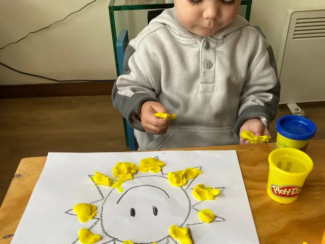 Niño pintando un sol con témpera