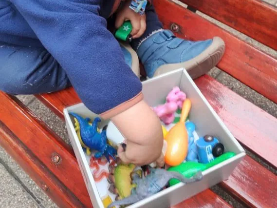 Niño explorando una caja de juguetes durante una actividad sensorial